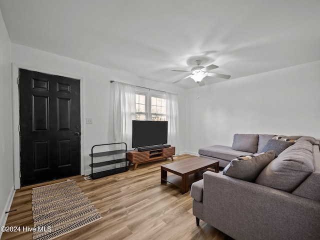 living room featuring wood-type flooring and ceiling fan