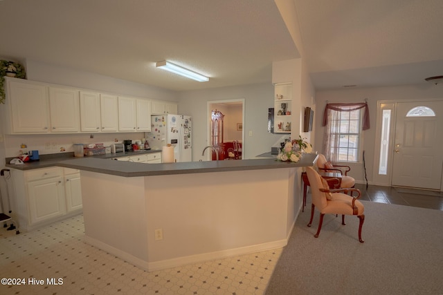 kitchen featuring white cabinetry, white fridge with ice dispenser, and sink