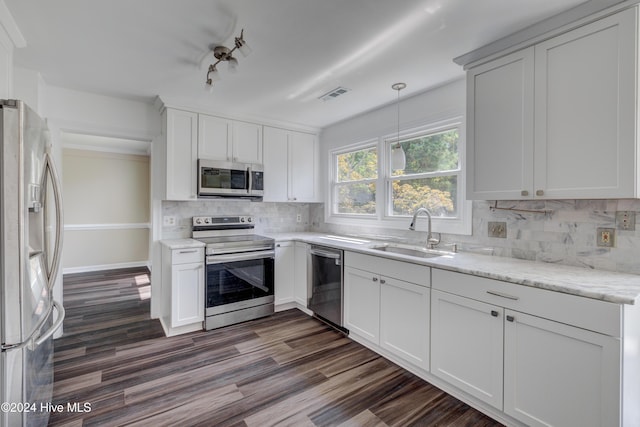 kitchen featuring appliances with stainless steel finishes, white cabinetry, hanging light fixtures, and sink