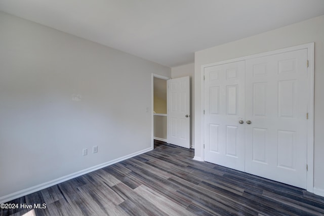 unfurnished bedroom featuring dark hardwood / wood-style flooring and a closet