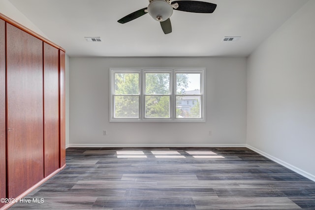 unfurnished bedroom with a closet, ceiling fan, and dark hardwood / wood-style floors