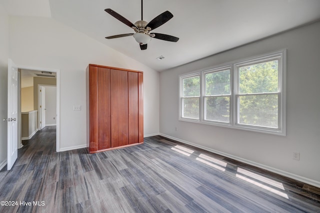 unfurnished bedroom with dark hardwood / wood-style flooring, ceiling fan, a closet, and vaulted ceiling