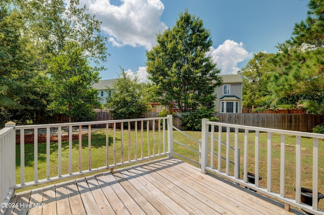 wooden deck featuring a lawn