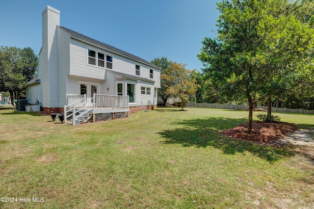 back of house featuring central air condition unit, a wooden deck, and a yard