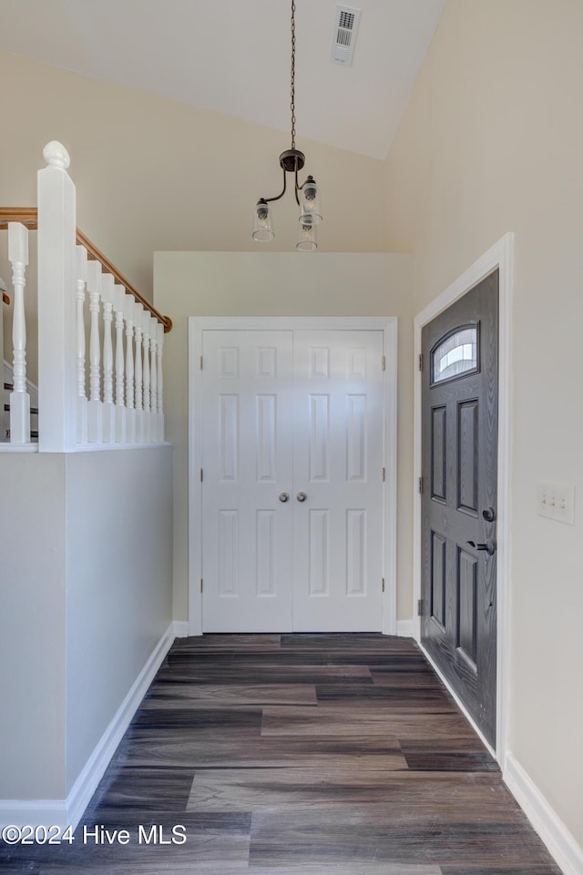 foyer with dark hardwood / wood-style flooring and vaulted ceiling