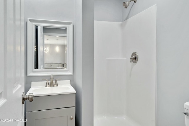 bathroom featuring a shower, vanity, and toilet