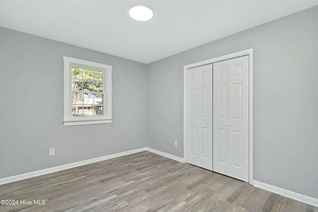 unfurnished bedroom featuring light hardwood / wood-style flooring and a closet