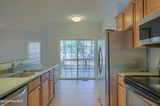 kitchen featuring appliances with stainless steel finishes, light wood-type flooring, and sink