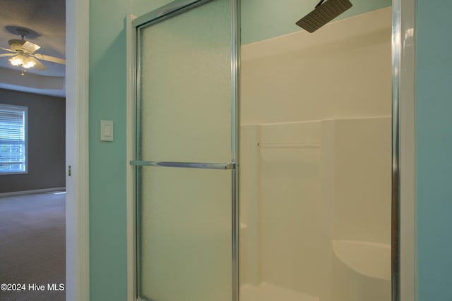 bathroom featuring ceiling fan and a shower with shower door