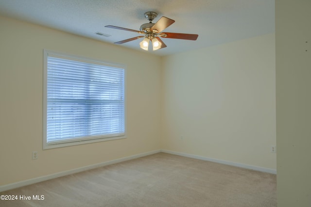 spare room with light carpet, a textured ceiling, and ceiling fan