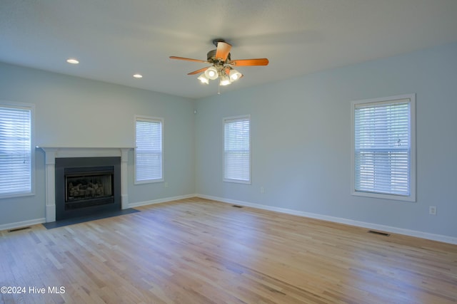 unfurnished living room featuring ceiling fan and light hardwood / wood-style flooring