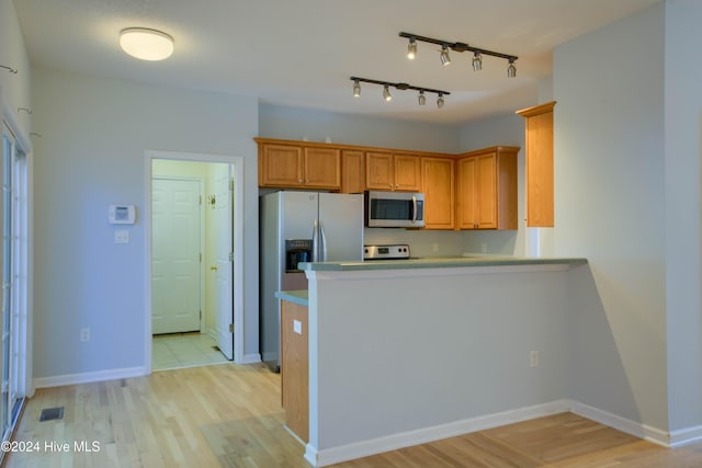 kitchen with light hardwood / wood-style floors, kitchen peninsula, and stainless steel appliances