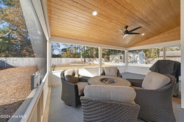 sunroom featuring lofted ceiling, ceiling fan, and wood ceiling