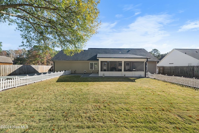 back of house featuring a patio, a lawn, and a sunroom