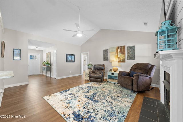 living room featuring ceiling fan, dark hardwood / wood-style flooring, and vaulted ceiling