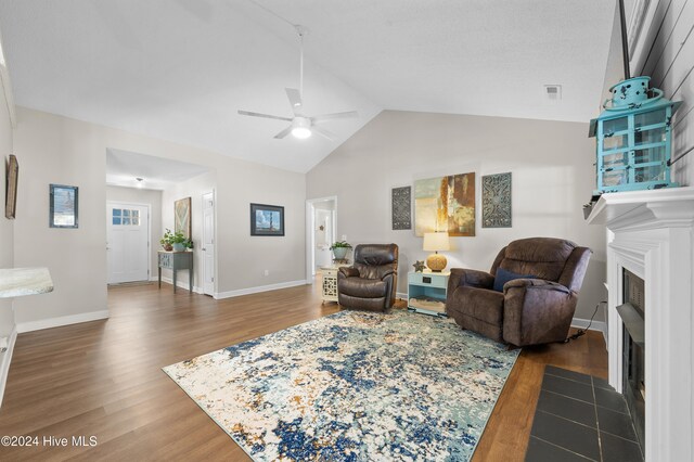 living room with vaulted ceiling, ceiling fan, and dark hardwood / wood-style floors