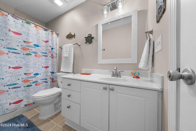 bathroom featuring tile patterned flooring, a textured ceiling, vanity, and toilet