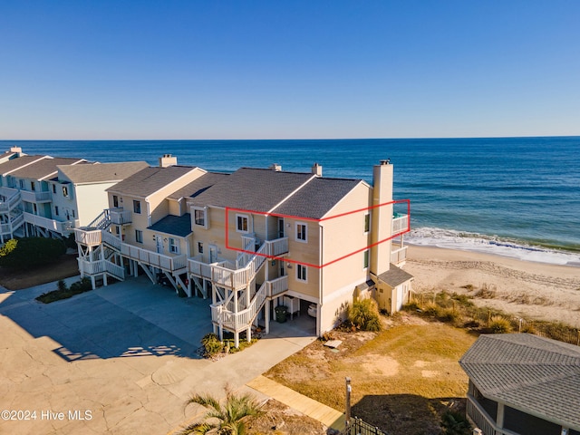 drone / aerial view featuring a water view and a beach view