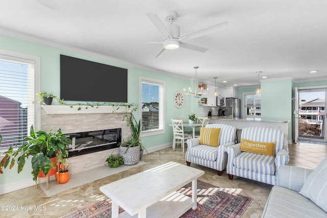 tiled living room featuring ceiling fan, a healthy amount of sunlight, and ornamental molding