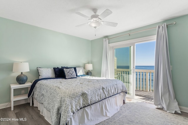 bedroom with wood-type flooring, a water view, ceiling fan, and access to outside