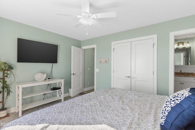 bedroom with a closet, ensuite bathroom, ceiling fan, and sink