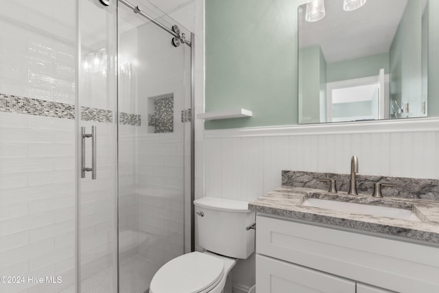 bathroom featuring toilet, vanity, and walk in shower