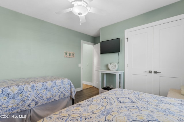 bedroom featuring ceiling fan, a closet, and dark wood-type flooring