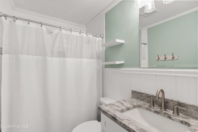 bathroom featuring vanity, toilet, ornamental molding, and a textured ceiling