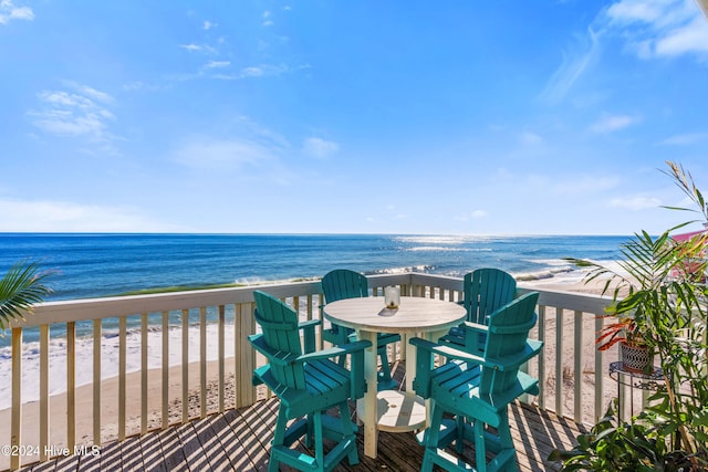 balcony with a water view and a view of the beach