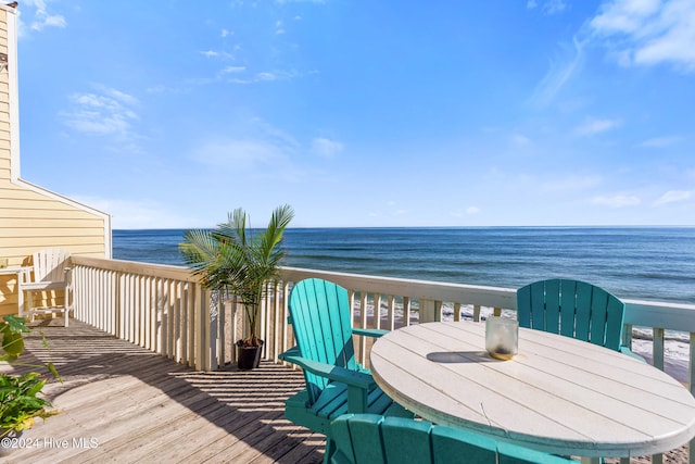 wooden terrace with a water view and a view of the beach