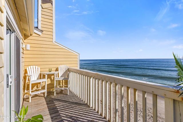 balcony with a water view and a beach view