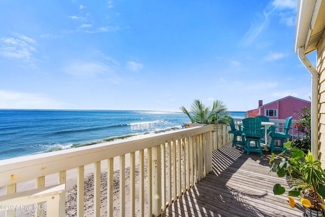 balcony featuring a water view and a beach view