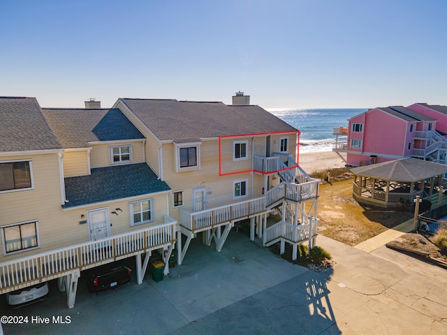 back of house featuring a carport and a water view