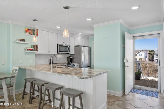 kitchen with kitchen peninsula, white cabinetry, plenty of natural light, and appliances with stainless steel finishes