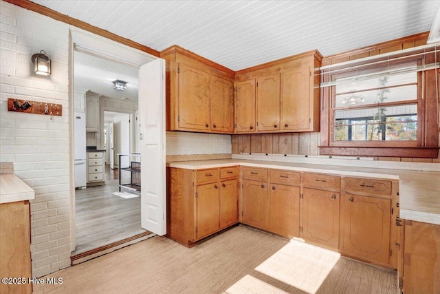 kitchen featuring white refrigerator, light hardwood / wood-style floors, and decorative backsplash