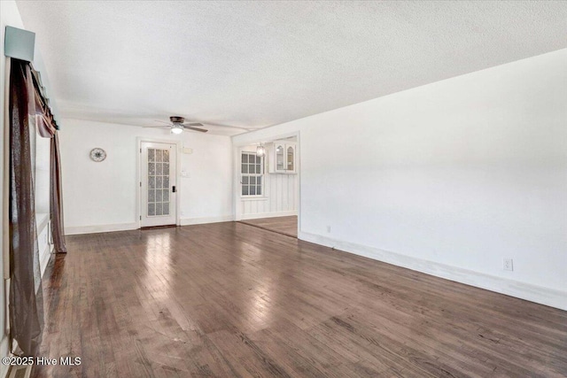 unfurnished living room with ceiling fan, dark wood-type flooring, and a textured ceiling