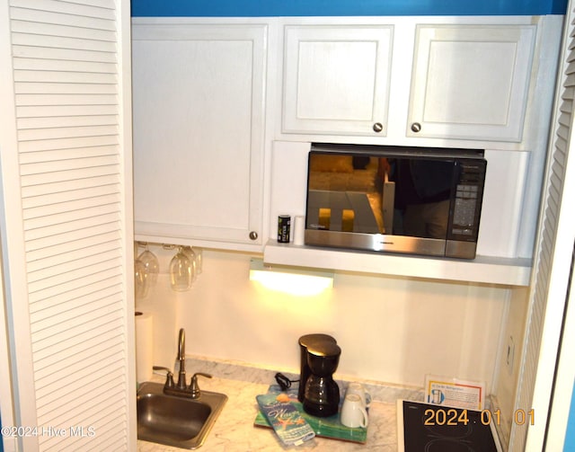 bar with sink and white cabinets