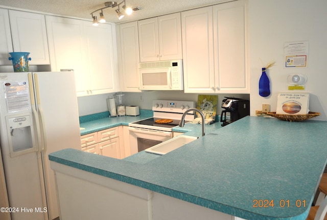 kitchen featuring white cabinetry, sink, a textured ceiling, track lighting, and white appliances