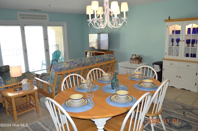 tiled dining area featuring french doors and an inviting chandelier