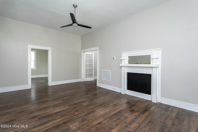 unfurnished living room featuring ceiling fan and dark hardwood / wood-style floors