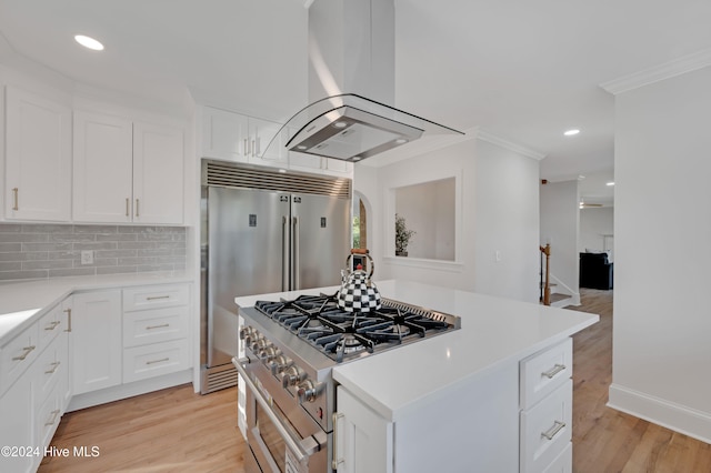 kitchen with island exhaust hood, light wood-type flooring, white cabinets, and high end stainless steel range