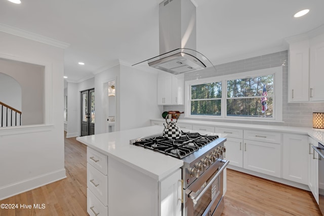 kitchen with ventilation hood, white cabinetry, and a wealth of natural light