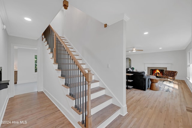 stairs featuring hardwood / wood-style flooring and ceiling fan