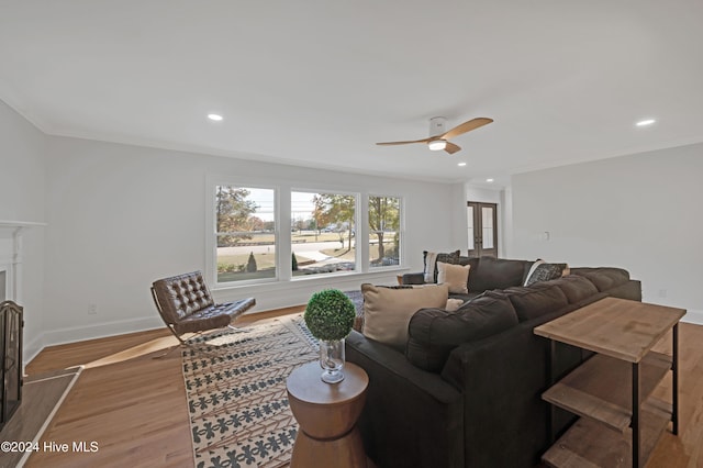 living room featuring hardwood / wood-style flooring, ceiling fan, and ornamental molding