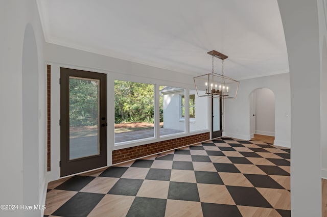 unfurnished dining area with a chandelier and ornamental molding