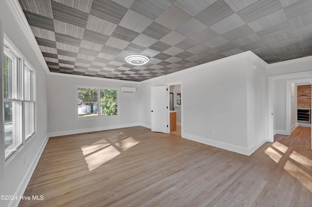 empty room with light wood-type flooring and a wall unit AC