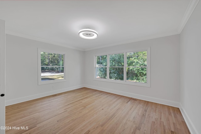 empty room featuring crown molding and light hardwood / wood-style flooring