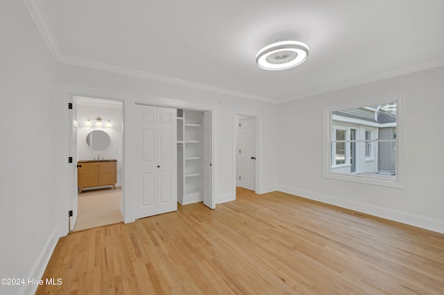 unfurnished bedroom with ensuite bathroom, crown molding, and light hardwood / wood-style flooring