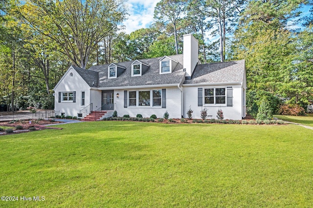 new england style home featuring a front lawn