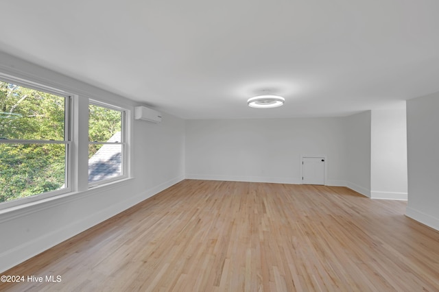 spare room featuring light hardwood / wood-style flooring and a wall mounted AC